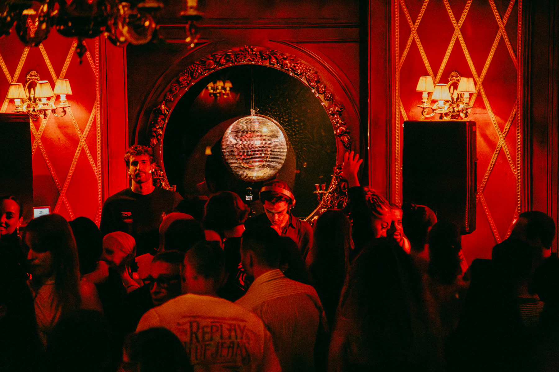 Booth framed by red diamond panels and a mirror ball