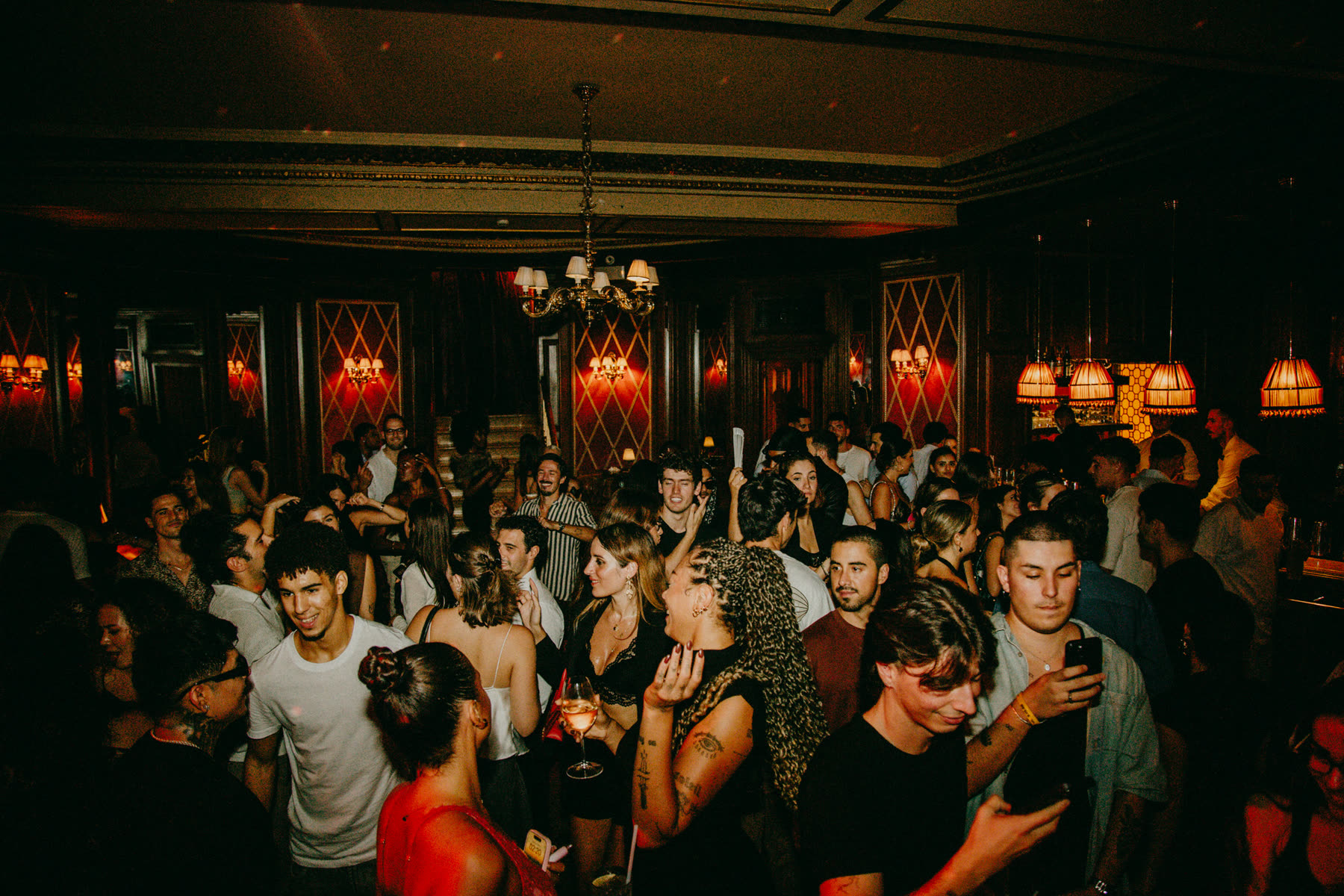 Packed, smiling crowd in a red-lit room